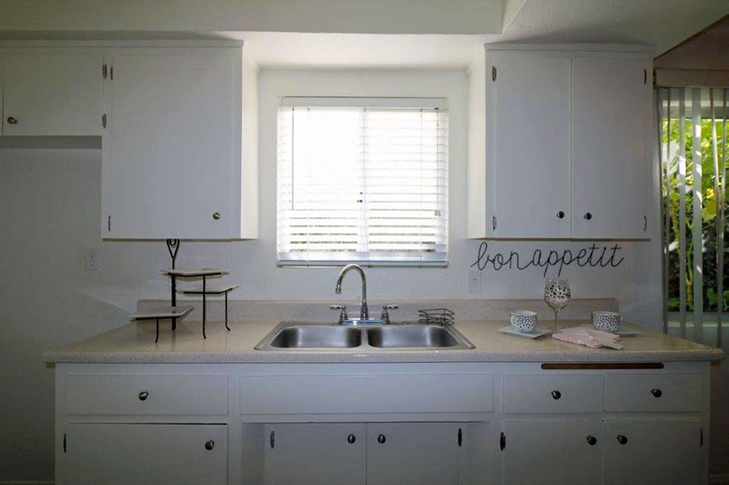 a kitchen with a sink and some white cabinets