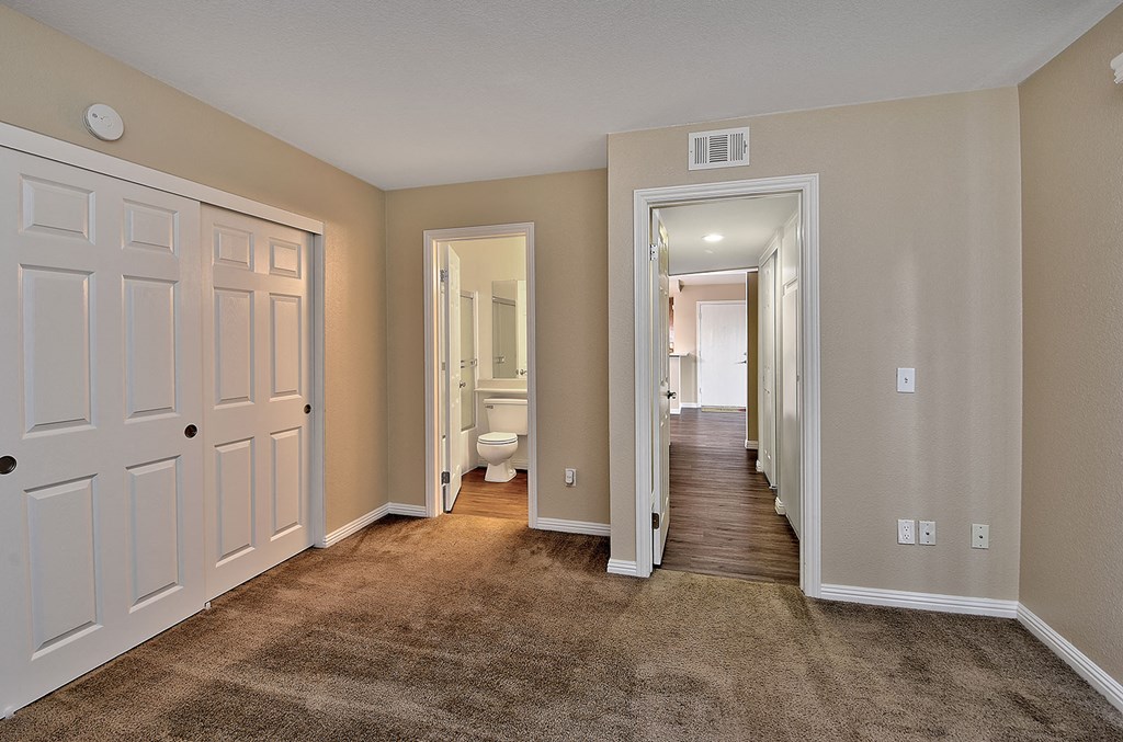 a spacious hallway with a carpeted floor and white doors