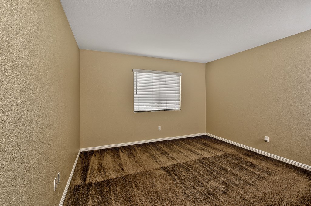an empty room with wood floors and a window