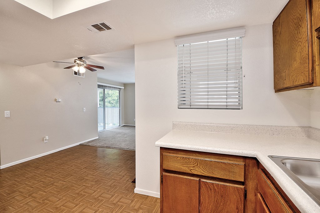 an empty kitchen with a sink and a ceiling fan