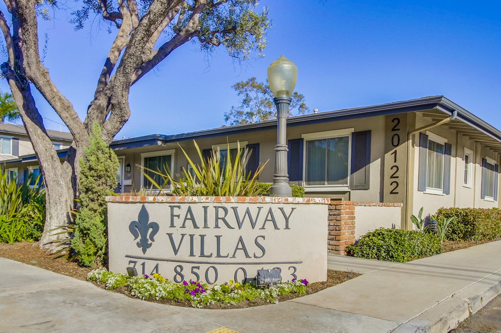 A sign for Fairway Villas is in front of a building.