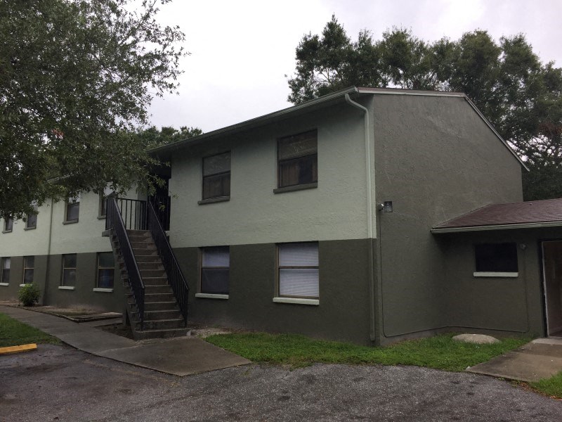 a green house with a staircase in front of it