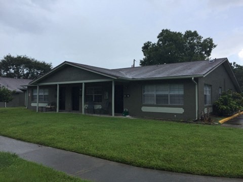 a green house with a lawn in front of it