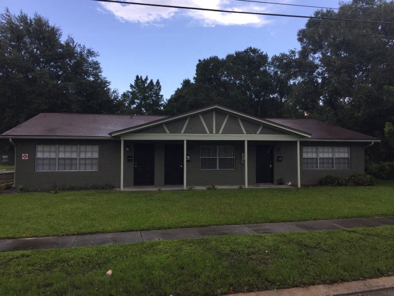 the front of a house with a lawn and a sidewalk