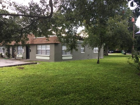 a house in the middle of a yard with trees