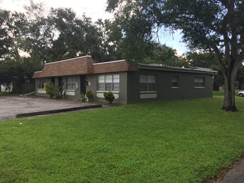 a house with a lawn and trees in front of it