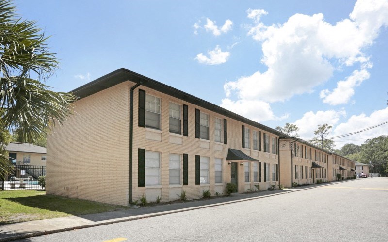 a row of brick apartment buildings on the side of a street
