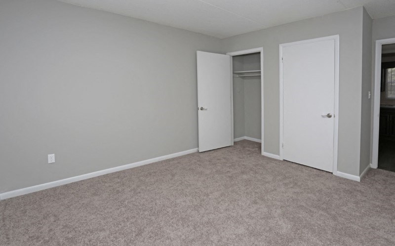 an empty living room with a door to a closet