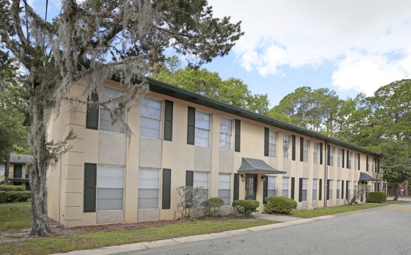 an apartment building with a tree in front of it
