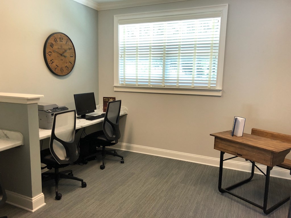 an office with two desks and a clock on the wall