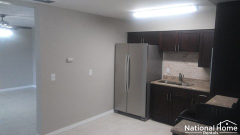 a kitchen with a stainless steel refrigerator and a sink