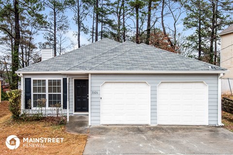the front of a white garage with a white door