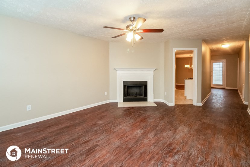 the living room and dining room with wood flooring and a fireplace