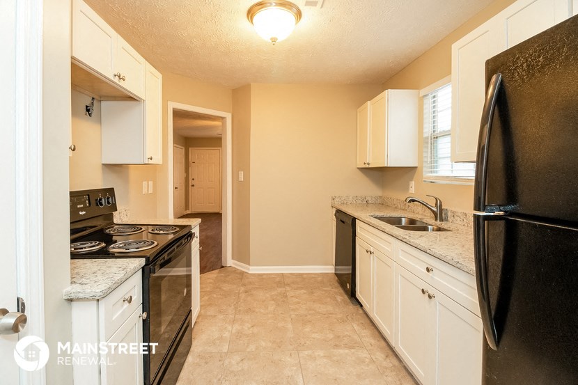 a kitchen with black appliances and white cabinets