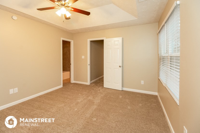 the master bedroom is spacious and has a ceiling fan and window