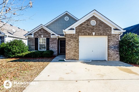 a small brick house with a white garage door