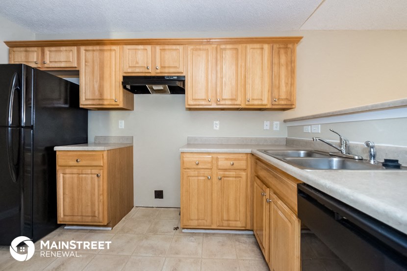 a kitchen with wooden cabinets and black appliances