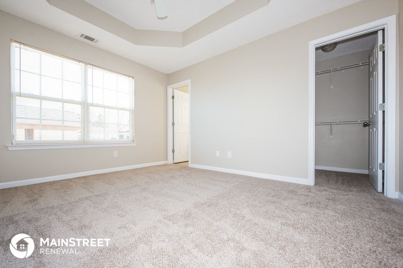 an empty living room with a door to a closet
