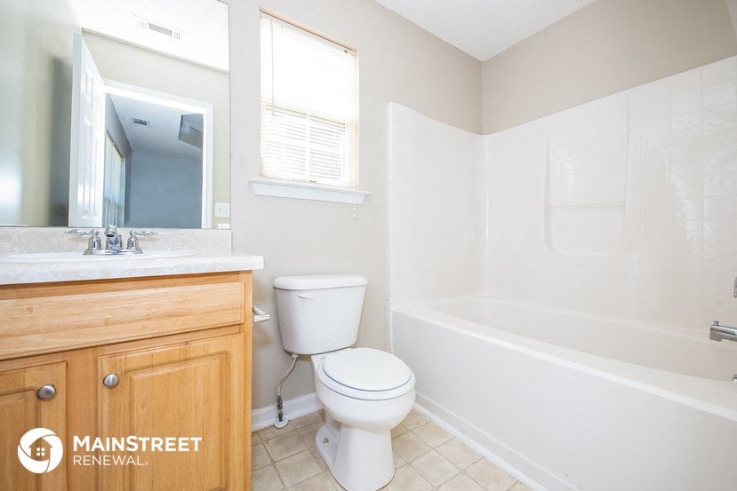 a bathroom with a toilet and a tub and a sink