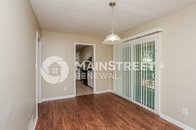 a bedroom with a large window and a door to a hallway