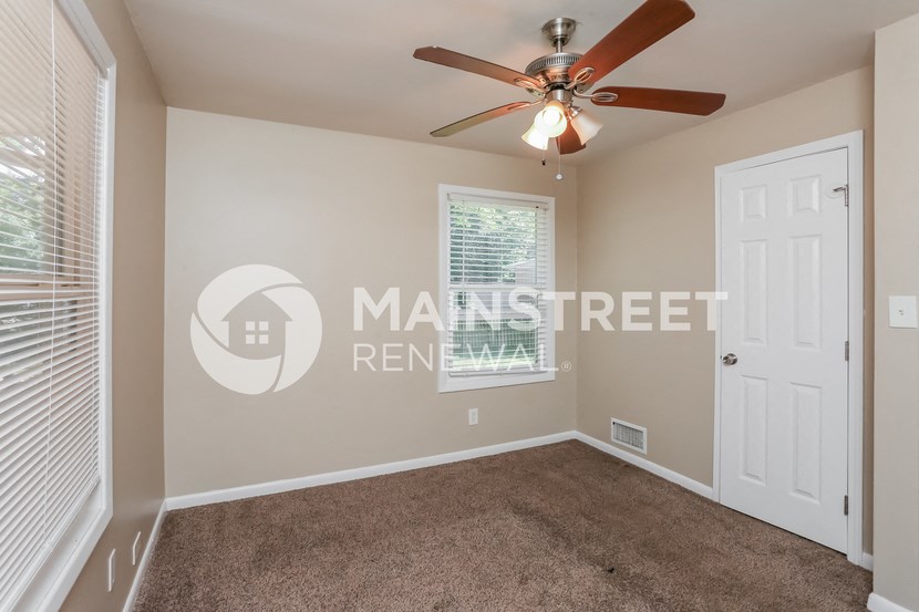 a bedroom with a ceiling fan and a closet