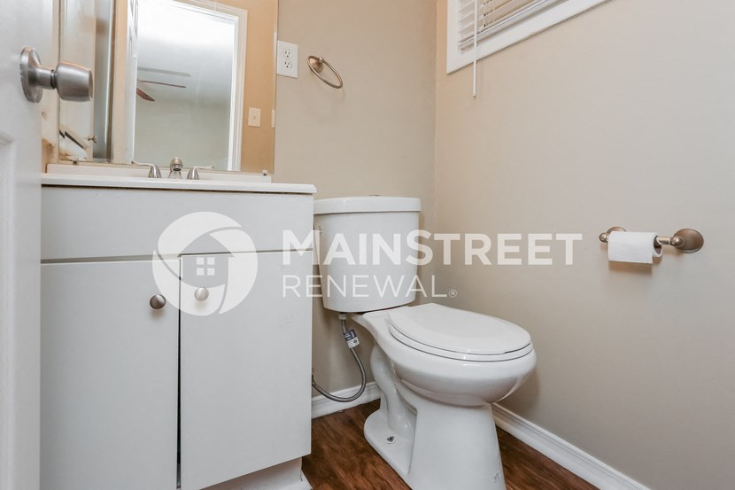 a bathroom with a toilet and a sink and a mirror