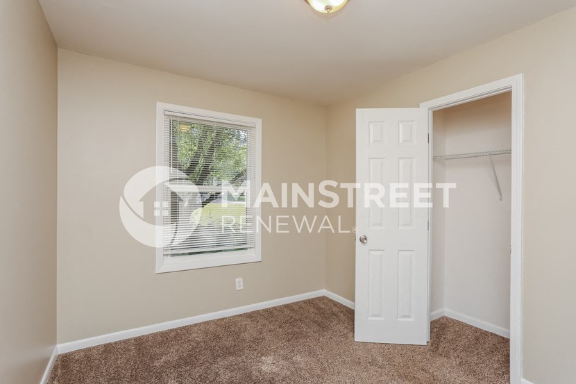 a bedroom with a closet and a white door
