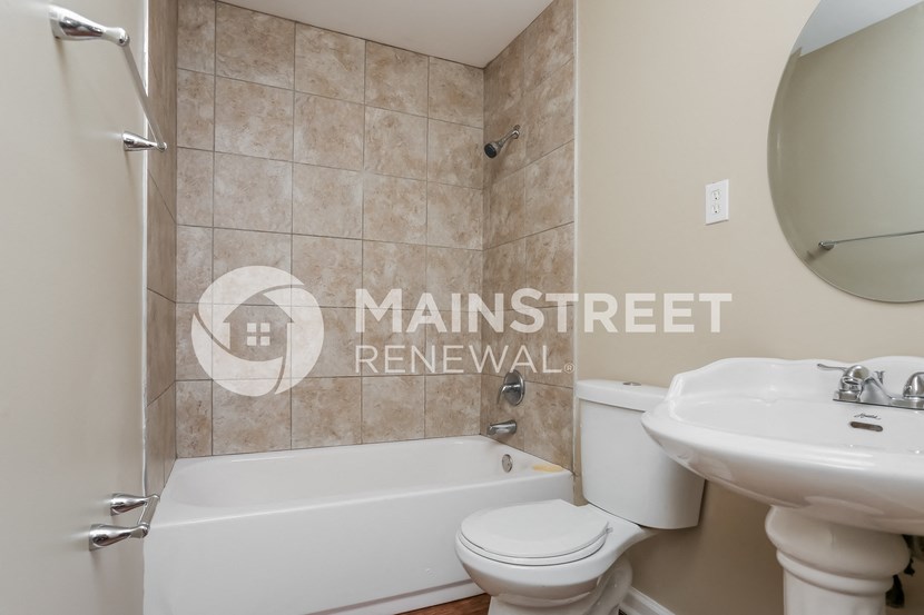 a bathroom with a toilet and a sink and a bath tub