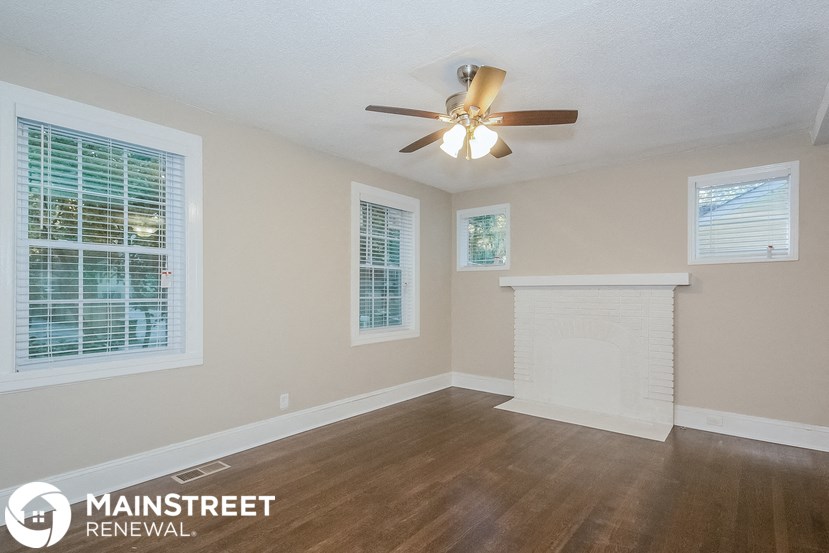 a living room with a ceiling fan and a fireplace