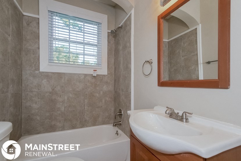 a bathroom with a sink and a tub and a mirror