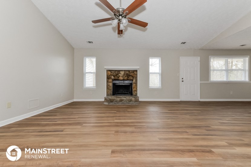 the living room with wood floors and a fireplace