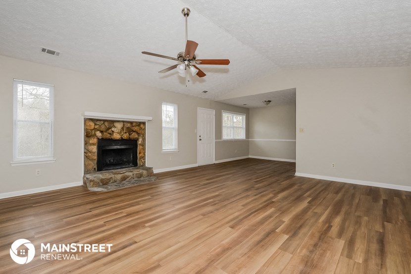 the living room with wood floors and a fireplace