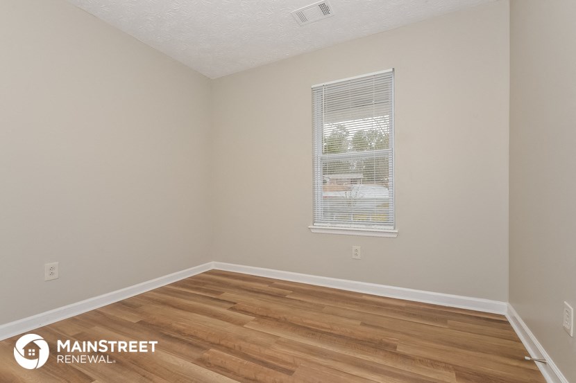 the interior of an empty room with wooden floors and a window