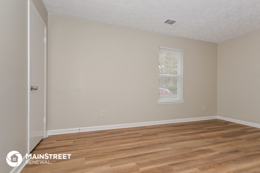 the interior of an empty room with wooden floors and a window