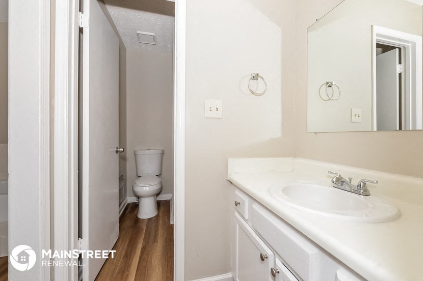 a bathroom with a sink and a toilet and a mirror