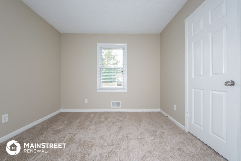 a bedroom with carpet and a white door