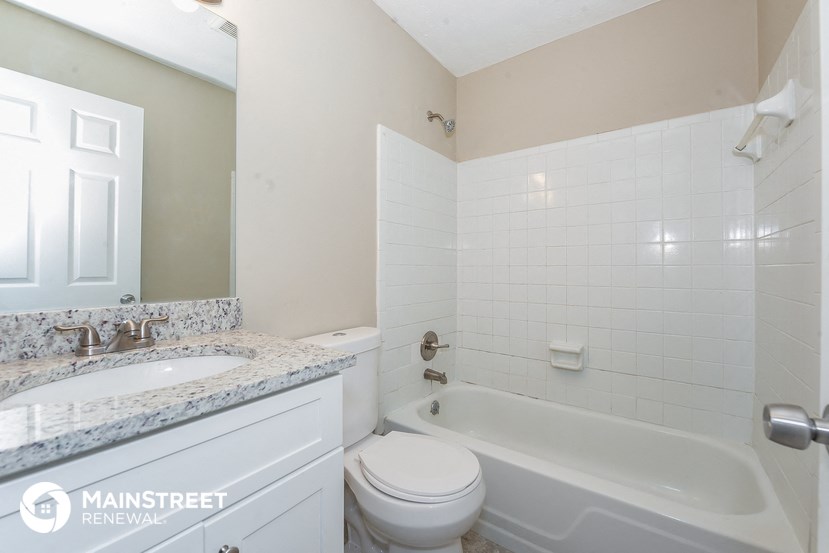 a white bathroom with a tub and a sink and a toilet