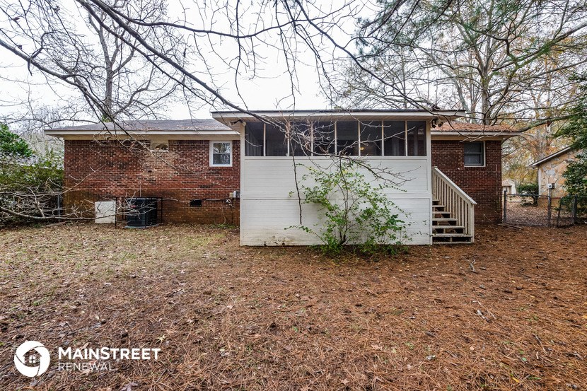 a small brick house with a garage and a staircase