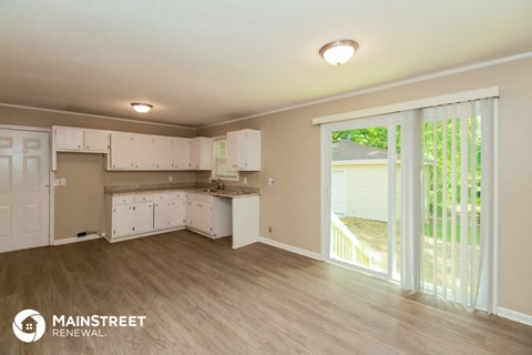 a kitchen with white cabinets and a sliding glass door