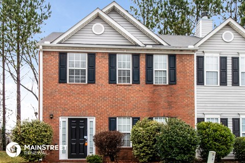 a brick house with black shutters and a black front door