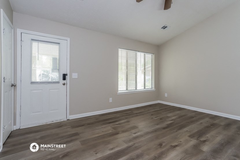 the spacious living room with a door to the bedroom