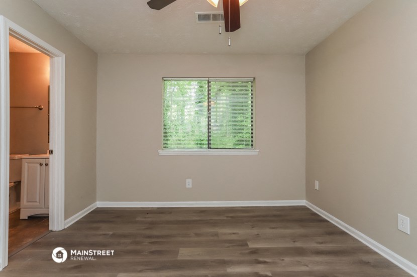 a empty room with a window and wooden floors