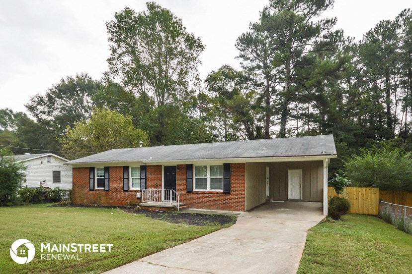 a small brick house with a porch and a sidewalk