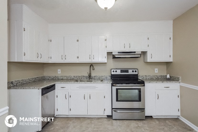 a kitchen with white cabinets and stainless steel appliances