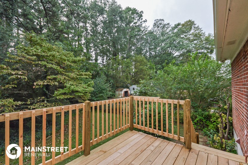 a balcony with a wooden railing and trees