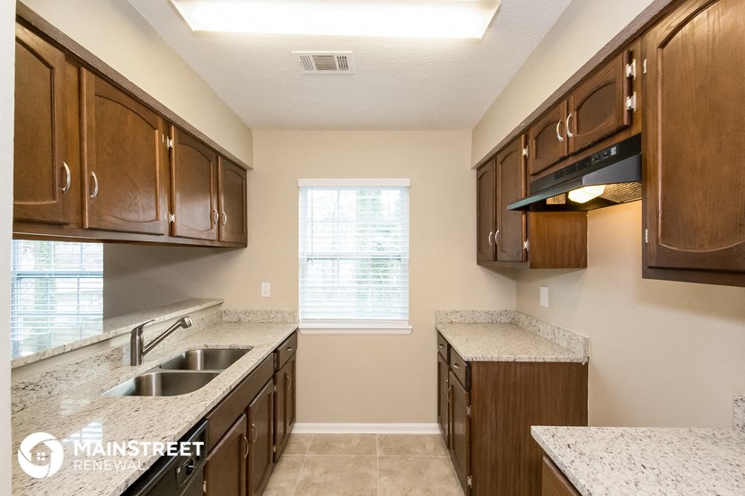 a kitchen with wood cabinets and granite counter tops and a sink