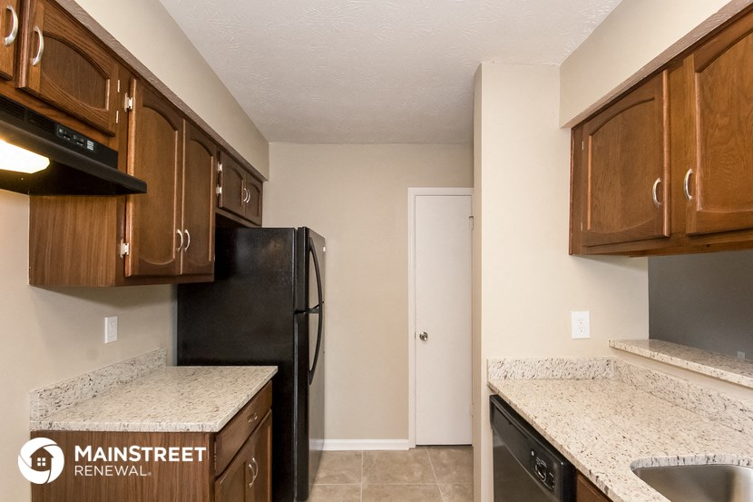 a kitchen with wooden cabinets and a black refrigerator
