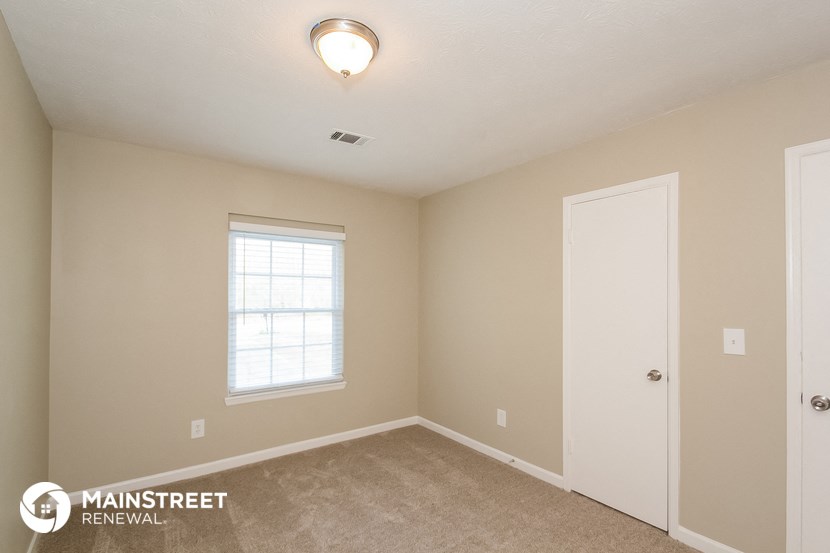 the interior of a bedroom with a door and a window