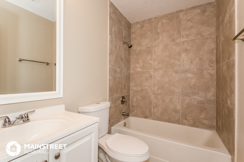 a bathroom with a sink toilet and bath tub and a mirror