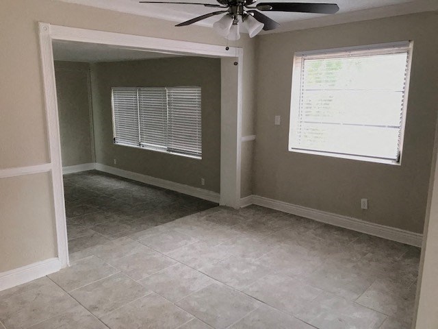 an empty room with a ceiling fan and a window
